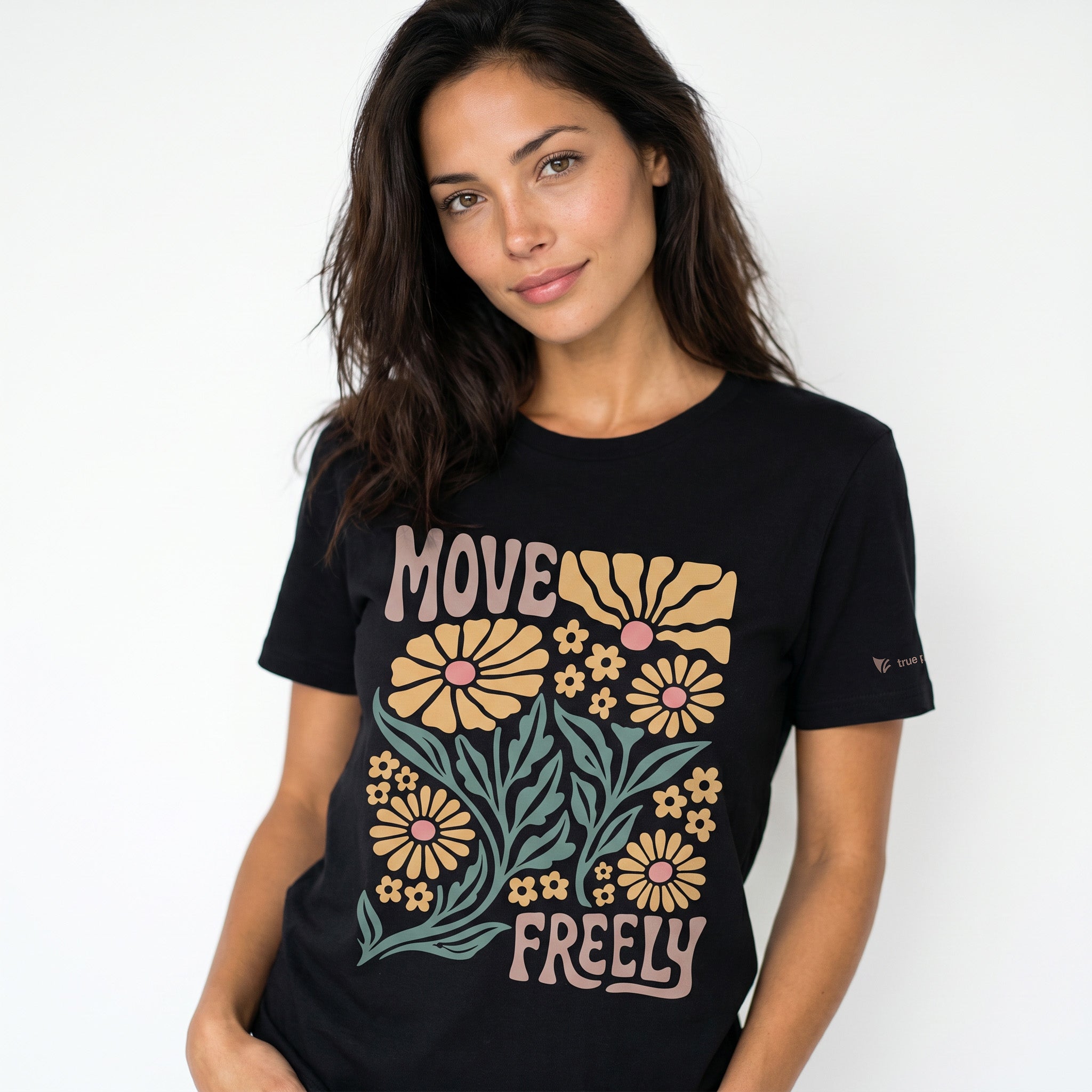 Woman wearing a black t-shirt with floral design and 'MOVE FREELY' text on a white background