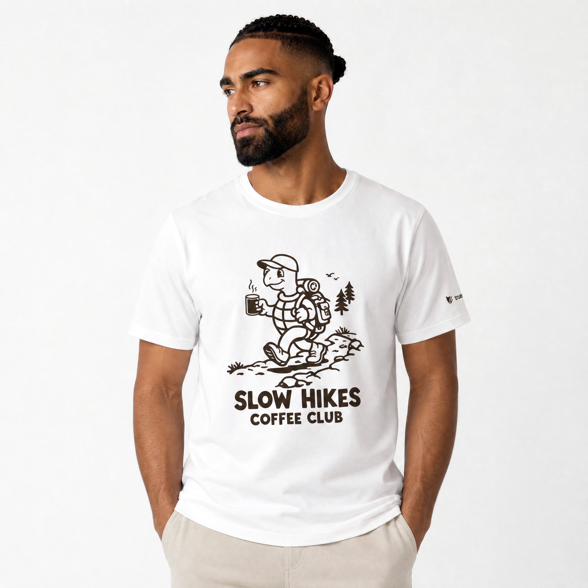 Man wearing a white t-shirt with 'Slow Hikes Coffee Club' design on a white background