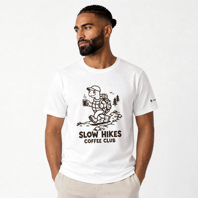Man wearing a white t-shirt with 'Slow Hikes Coffee Club' design on a white background
