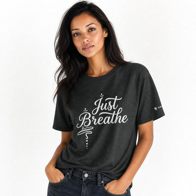 Woman wearing a dark heather grey t-shirt with 'Just Breathe' text on a white background