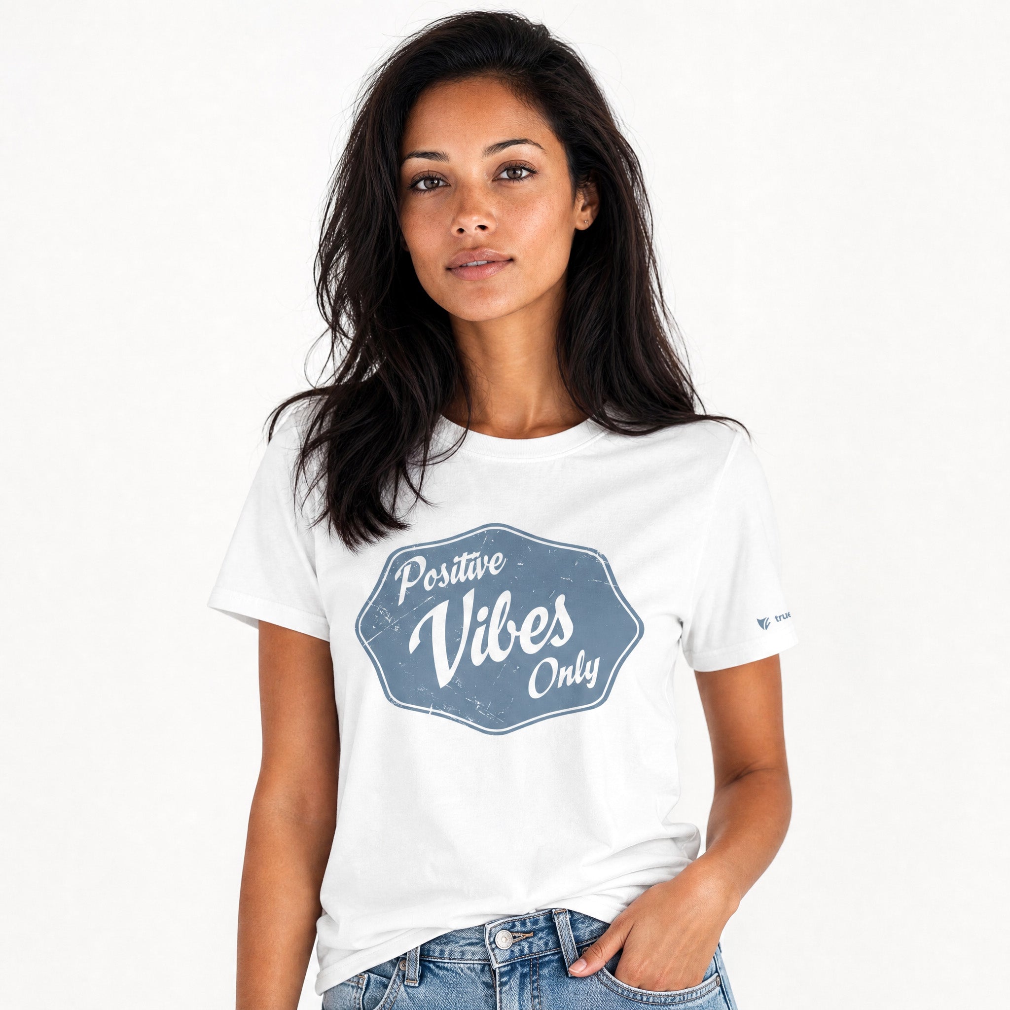 Woman wearing a white t-shirt with 'Positive Vibes Only' text on a plain background